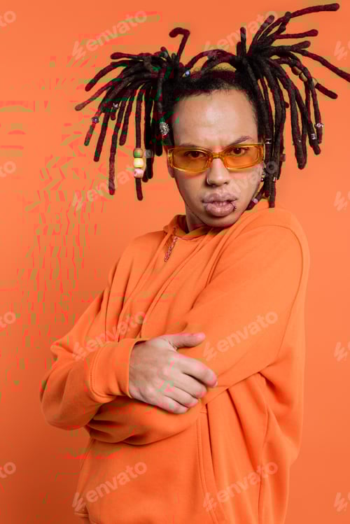 Preview: serious multiracial man in hoodie and stylish sunglasses isolated on coral