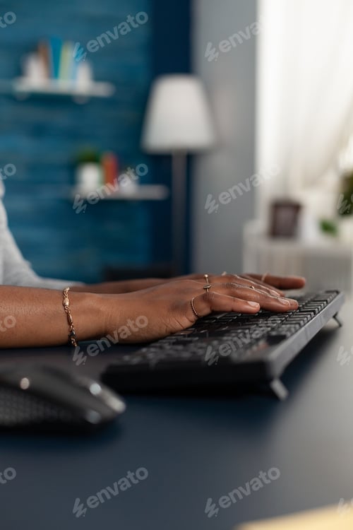 Preview: Closeup of black student working remote at education project typing information on keyboard