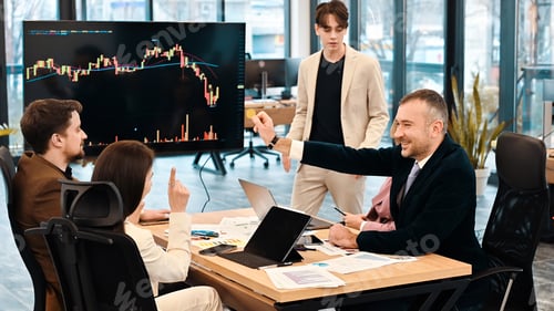 Preview: Young worker leading business meeting about cryptocurrencies in an office