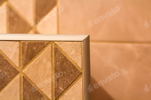 Preview: Close-up of ceramic tiles out corner with silver metal strip on the interior wall.