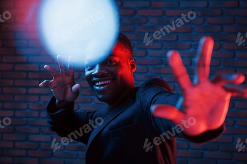 Preview: Light blinks. Futuristic neon. Young african american man in the studio