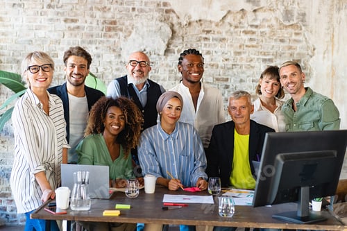 Preview: Portrait of successful group of multiethnic business people at modern office looking at camera
