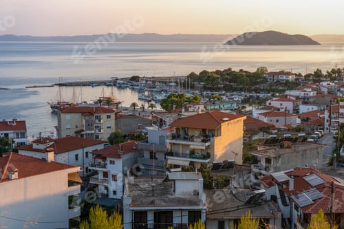 Preview: Red roofs of houses and a rock in the sea in Greece aerial view