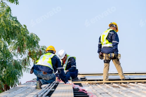 Preview: workers installing solar panels, for efficient energy on rooftop