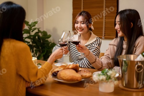 Preview: Young smiling woman drinking and clinking glass of wine to toast