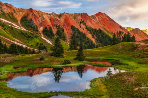 Preview: a pond in a green field next to mountains and clouds
