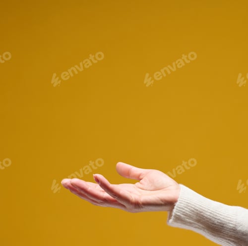 Preview: Open female palm on a yellow background, holding something