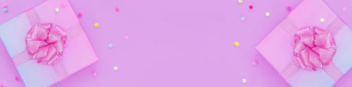 Preview: gift box with a pink bow on a pink background with colorful pompoms