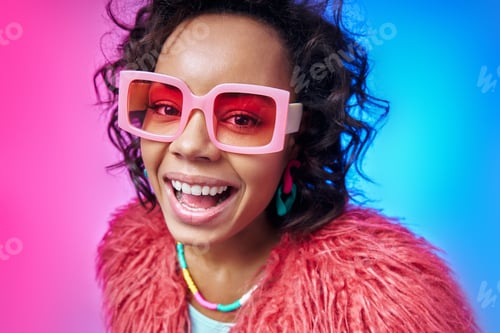 Preview: Happy African woman in funky eyeglasses looking at camera while standing against colorful background