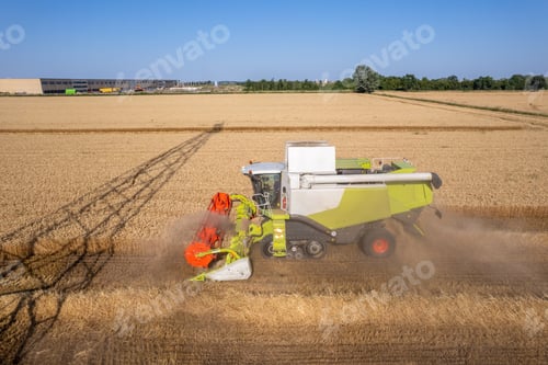 Preview: AAerial shot of harvester machinery collecting wheat grain in hot season in rural cultivated fields