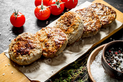 Preview: Cutlets on paper with tomatoes.