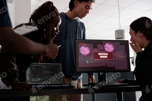 Preview: Team of software developers looking at monitor dealing with security breach alert