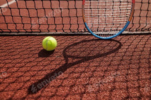Preview: Tennis Ball and Racket Near Net on Clay Court During Outdoor Match