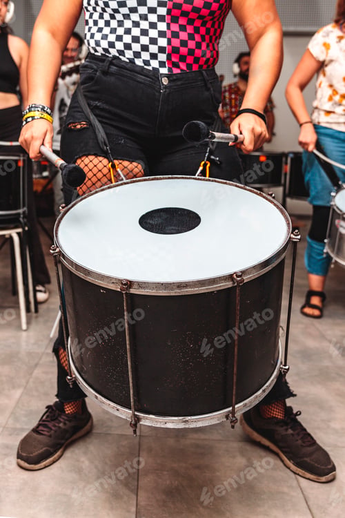 Preview: Unrecognizable woman plays a drum with maces