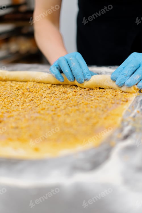 Preview: The kitchen in the bakery process of making cinnabons the woman baker adds chocolate dough