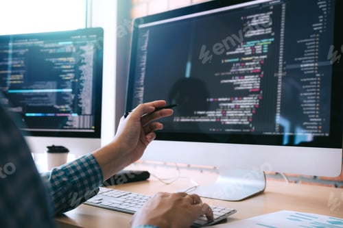 Preview: Software developer holds the pen pointing to the computer screen and is analyzing the code.