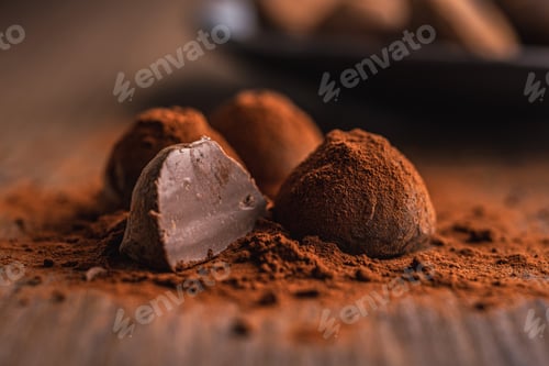 Preview: Chocolate truffles covered with cocoa powder on wooden table.