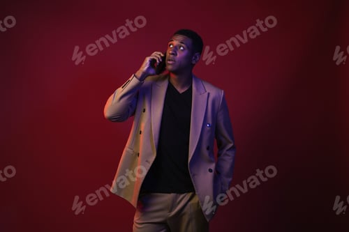 Preview: Young black man dressed in jacket talking on mobile phone