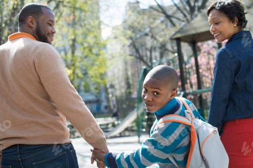 Preview: A New York city park in the spring. A boy looking over his shoulder, between his parents.