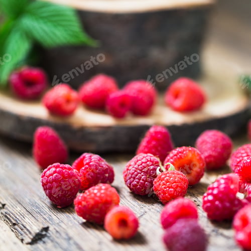 Preview: Fresh raspberry with leaves on a wooden table outdoors