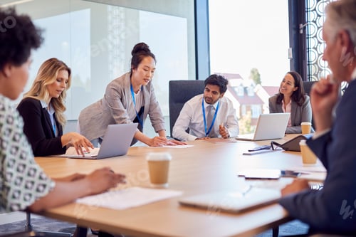 Preview: Businesswoman Leading Multi-Cultural Business Team Meeting And Collaborating Around Table In Office