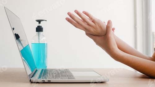 Preview: Asian woman using alcohol gel sanitizer wash hand before work on laptop for protect coronavirus.