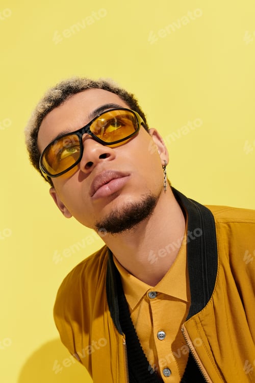 Preview: Young man showcases trendy bomber jacket in vibrant studio setting