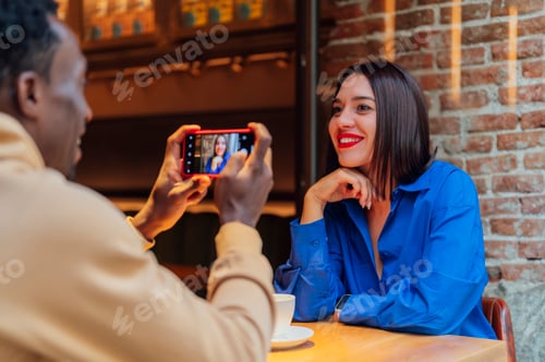 Preview: Young friends sitting together in the cafe taking a selfie.