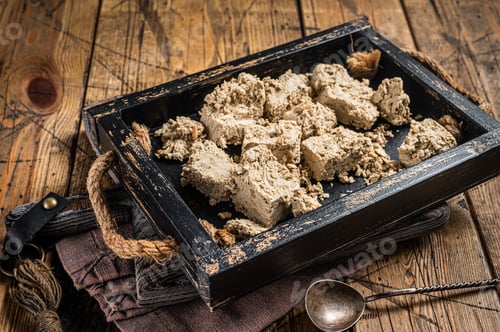 Preview: Turkish Halva with sunflower seeds and honey in wooden tray. Wooden background. Top view