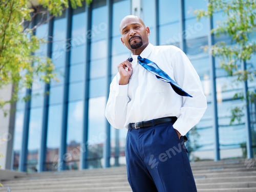 Preview: confident african businessman with tie blowing in the wind