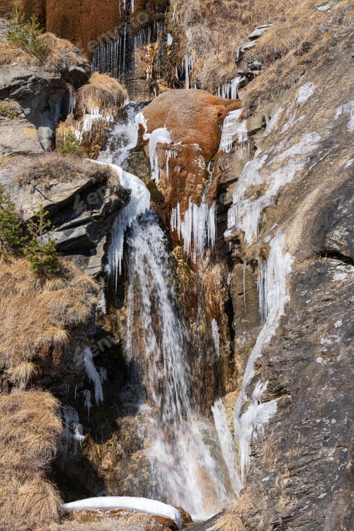 Preview: Vertical shot of a cascade icy waterfall