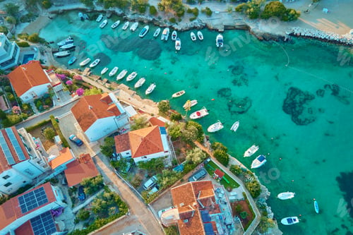 Preview: Coastal village with red-roofed houses, turquoise waters and boats along shore