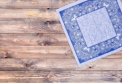 Preview: Blue napkin on wooden table, top view