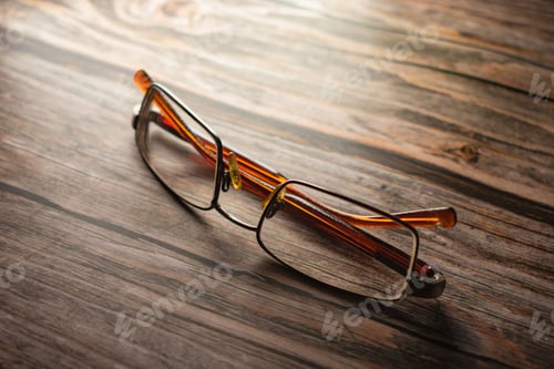 Preview: Old reading glasses lying on wooden table