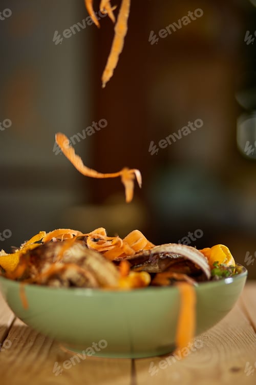 Preview: Women scraps peels carrots vegetable peeling, throws in compost bucket, organic composting