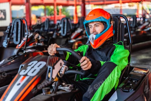 Preview: Man wearing helmet driving racing kart at track