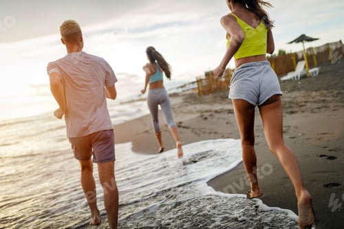 Preview: Group of people, friends running on the beach at sunset