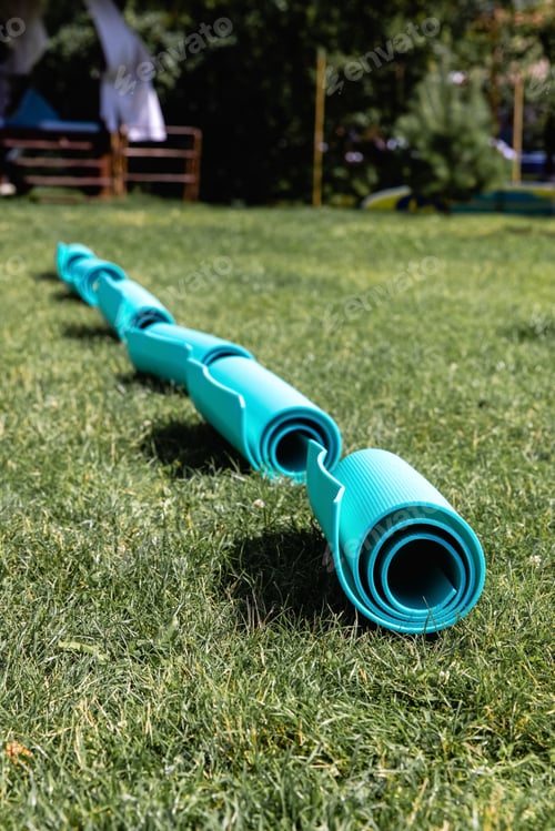 Preview: Blue yoga mat on green grass, close up photo, fitness concept