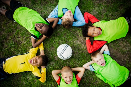 Preview: Junior football team lying around a football
