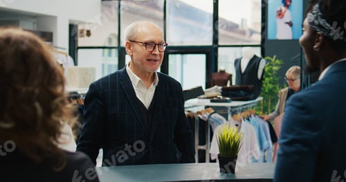 Preview: Showroom staff giving bag filled with clothing items to client