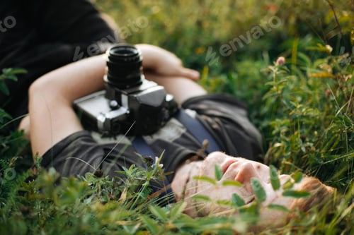 Preview: Handsome guy resting in nature and enjoying evening in mountains