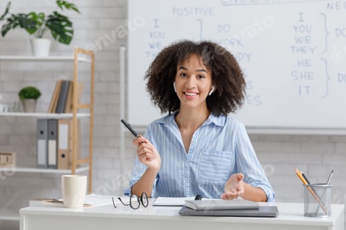 Preview: Teacher online remotely. Girl with wireless headphones, sits at table and explains rules of english