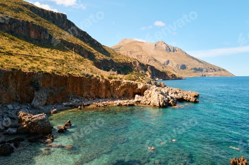 Preview: A scenic view of rocky coastline with clear blue water in Zingaro Nature Reserve, Sicily, Italy.