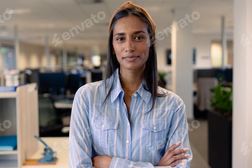Preview: Portrait of beautiful young female african american advisor with arms crossed at modern workplace