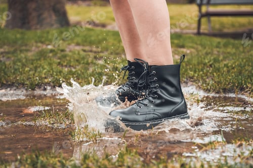 Preview: Person jumping over puddle in park