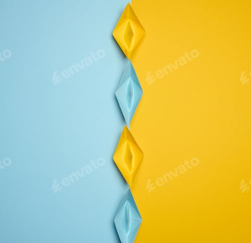 Preview: Paper boats on a yellow background, top view, representing the concept of unity