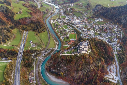 Preview: Aerial view of green meadows with villages and forest in austrian Alps mountains.