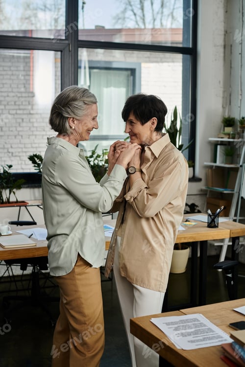 Charming Senior Women Holding Hands in an Office