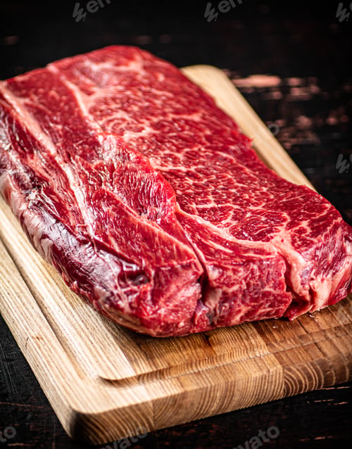 Vista previa: A piece of fresh raw beef on a cutting board.