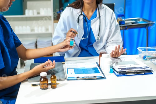 Visualização: Um close-up de dois médicos discutindo um frasco de remédio em uma mesa no hospital. Eles colaboram
